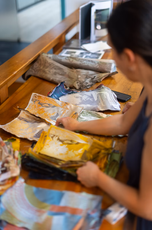 Sabine Verzier examining colorful fabric samples on a wooden table